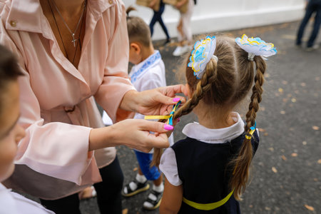 Shallow depth of field (selective focus) details with the Ukrainian flag bow in the hair of a girl schoolgirl.の写真素材