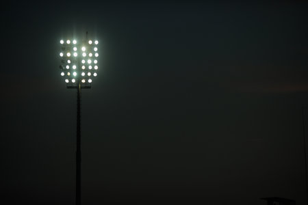 Lights of a stadium, some of them not working, during a game.の写真素材