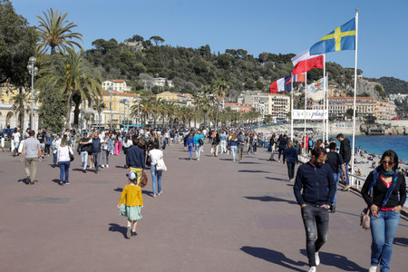 Nice, France - April 18, 2022: People walk on the boardwalk of the sea town of Nice on the French riviera during a sunny spring day.のeditorial素材