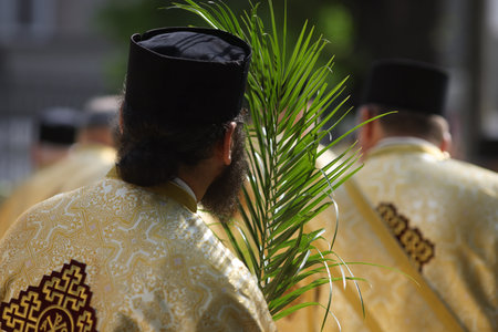 Romanian Orthodox priests holding palm leaves walk on the streets of Bucharest during a Palm Sunday pilgrimage procession.の写真素材