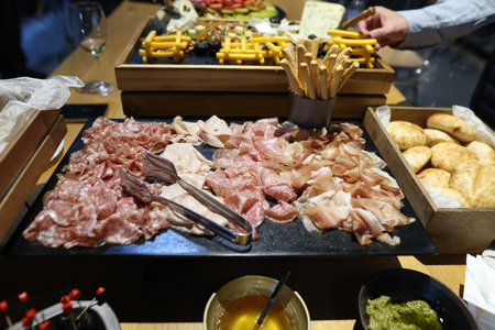 Shallow depth of field (selective focus) details with various meats (charcuterie) at a buffet.の写真素材