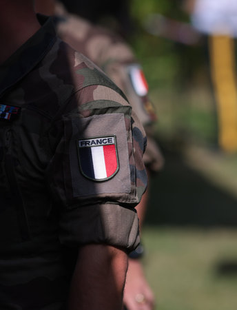 Shallow depth of field (selective focus) details with the French flag on the military uniform of a soldier.の写真素材