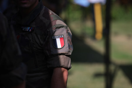 Shallow depth of field (selective focus) details with the French flag on the military uniform of a soldier.の写真素材