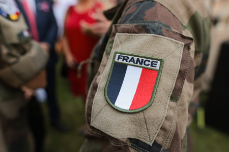 Shallow depth of field (selective focus) details with the French flag on the military uniform of a soldier.の写真素材