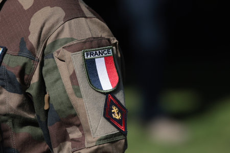 Shallow depth of field (selective focus) details with the French flag on the military uniform of a soldier.の写真素材