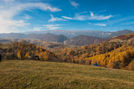 Scenic autumn overview of Magura village in Romania, near the Piatra Craiului mountains.の写真素材