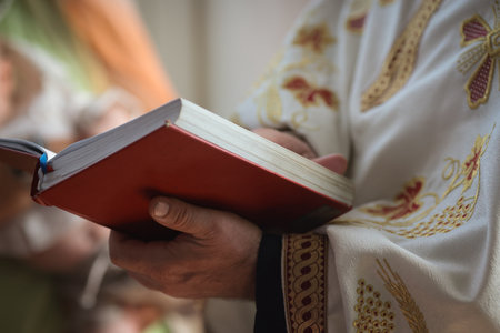 Shallow depth of field (selective focus) details with an orthodox priest in church during a baptism.