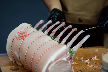 Details with the hands of a chef cooking pork ribs.の写真素材