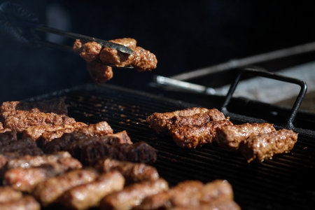 Romanian traditional mici (mititei or rolled minced meat) on an outside charcoal metal grill.の写真素材