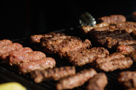 Romanian traditional mici (mititei or rolled minced meat) on an outside charcoal metal grill.の写真素材