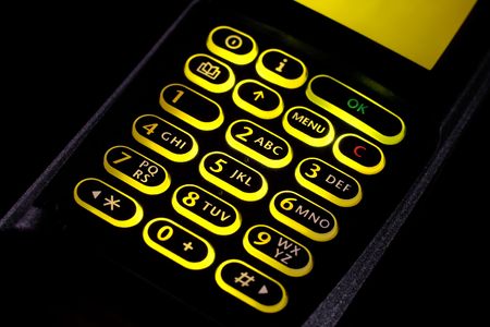 cellular phone keypad closeup lighted on black backgroundの写真素材