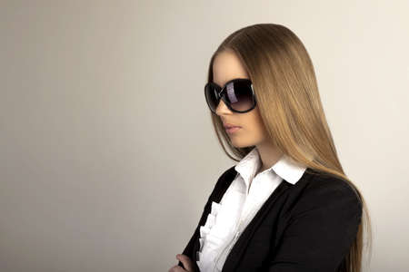 Beautiful blonde woman with sunglasses in studioの写真素材