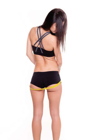 Young Woman measuring her waist - Stock Image