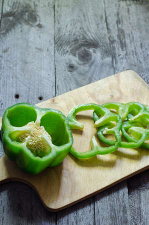 Photo of sliced green peppers over wooden tableの写真素材