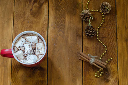 cup of hot chocolate with cinnamon and marshmallows on wooden backgroundの写真素材