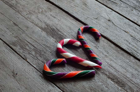 Three colourfull candy canes on a wooden background.の写真素材