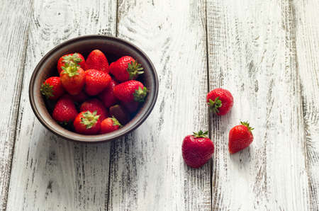 fresh ripe strawberry on wooden background in the plateの写真素材