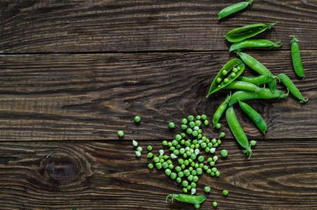 Fresh green peas on old wooden backgroundの写真素材