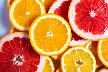 Slises of different citruses on the white background. Close-up of slised citruses.の写真素材