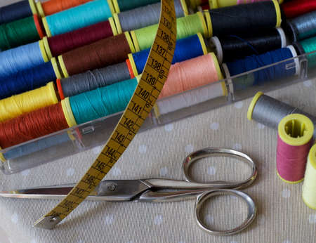 Sewing accessories and tools. Scissors, yellow sewing meter and set of color sewing threads