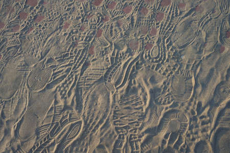 Imprint of shoes on sand. Many footprints. Background photo textureの写真素材