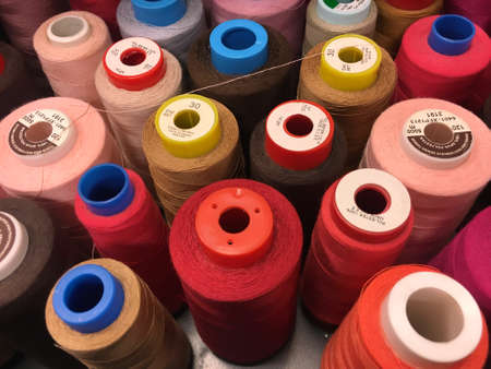 Set of sewing threads of varieties of color red. Threads of shades of red and brown on spools....