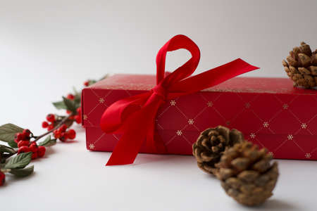 Close-up of Christmas present with a bow in white background. Details of beautiful red gift box. Santa Claus or secret santa present. Selected focusの写真素材