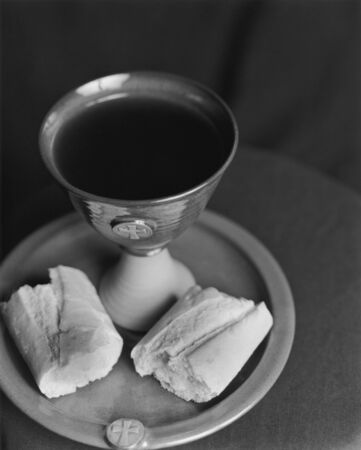 Communion setting with chalice, plate, wine and bread.の写真素材