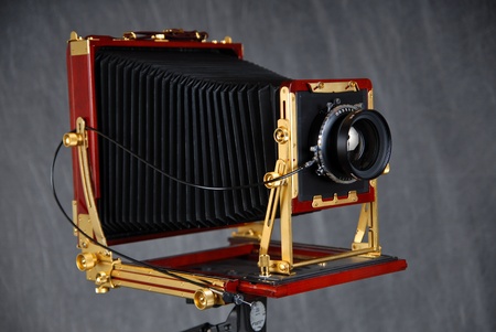 An 8x10 inch rosewood field camera with bellows, lens and cable release.