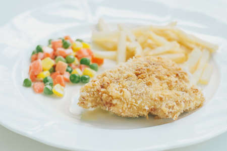 A chicken fried steak with french fries and vegetablesの写真素材