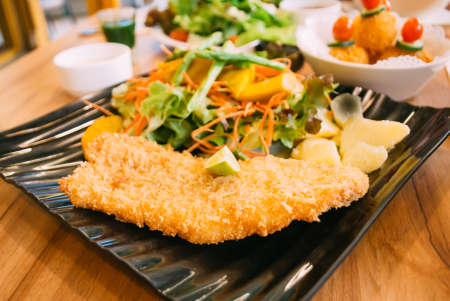 Fried fish with fresh saladの写真素材