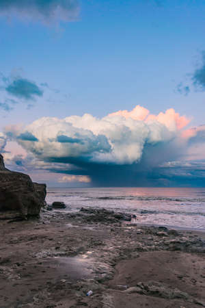 large storm clouds moving away over the blue seaの写真素材