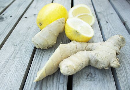 yellow bright sliced lemon and ginger on a grey wooden surfaceの写真素材
