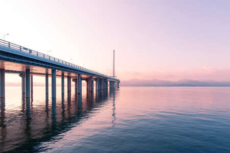 Beach side scenery with view of bridge during sunsetの写真素材