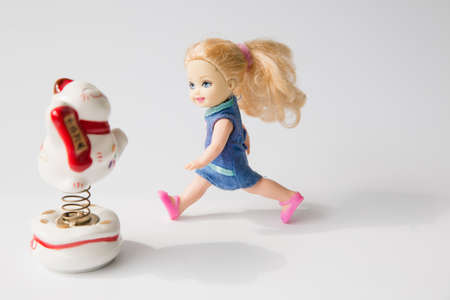 Little girl doll with a maneki Neko on white backgroundのeditorial素材