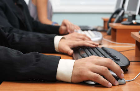 Closeup view of businessman's hands on a mouse and keyboardの写真素材