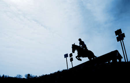 Silhouette of a horseman riding downhillの写真素材