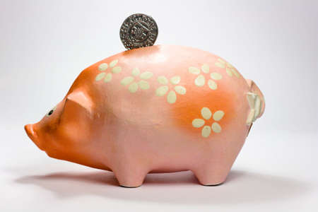 Ruddy piggy bank made of clay isolated on white backgroundの写真素材