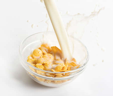 Milk flowing on a bowl of cornflakesの写真素材