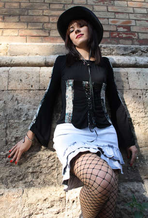 Young arrogant girl leaning over a brick wallの写真素材