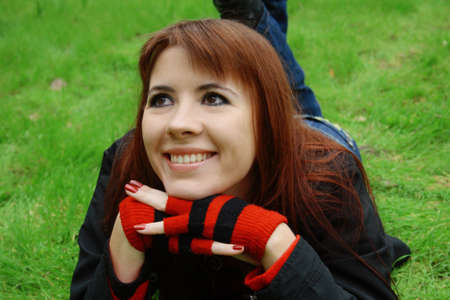 Young smiling woman, lying on green grassの写真素材