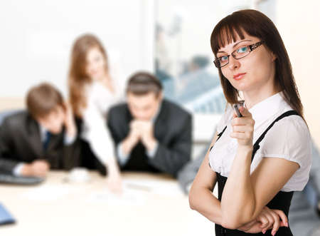 Businesswoman pointing at camera with her team on background, good for human resources issues.の写真素材