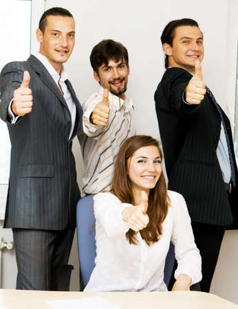 Successful business team showing thumbs up, focus on woman on foregroundの写真素材