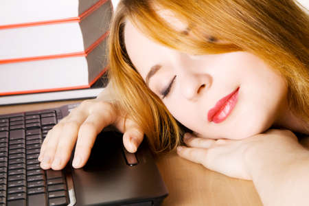 Young woman sleeping at her workplaceの写真素材
