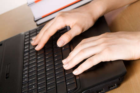 Hands of a woman working at her laptop, closeup photoの写真素材