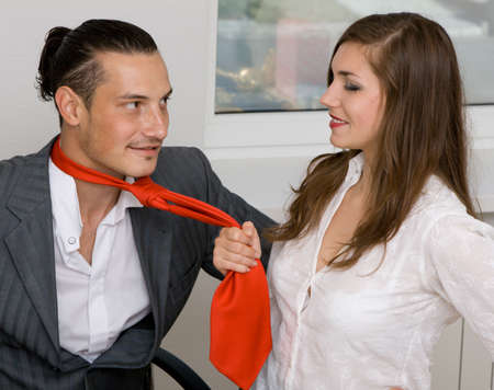 Young businessman and businesswoman flirting in officeの写真素材