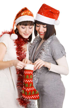 Two cheerful girls in Santa's hats taking out their christmas presentsの写真素材