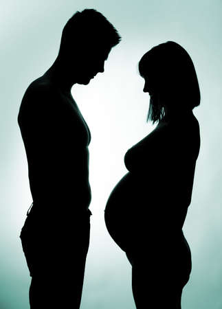 Silhouette of a young couple expecting a babyの写真素材
