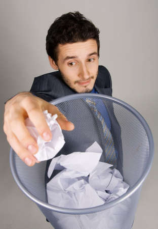 Young businessman playing baskteball with crumpled paperの写真素材