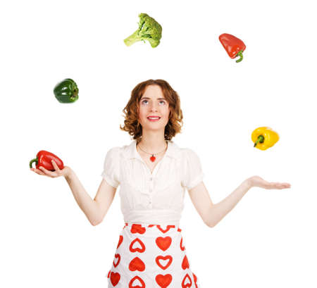 Young beautiful woman juggling with vegetables, white backgroundの写真素材